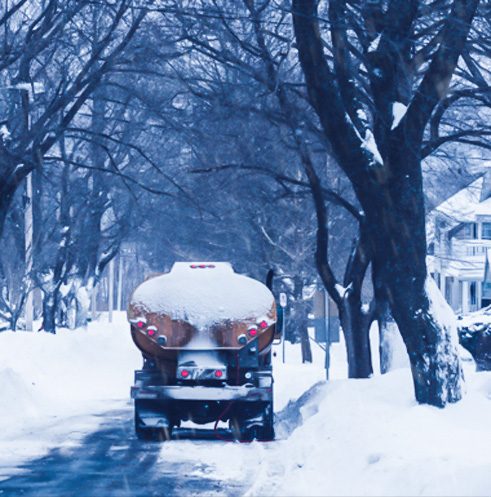 Heating oil truck making deliveries on a snow-covered Long Island street