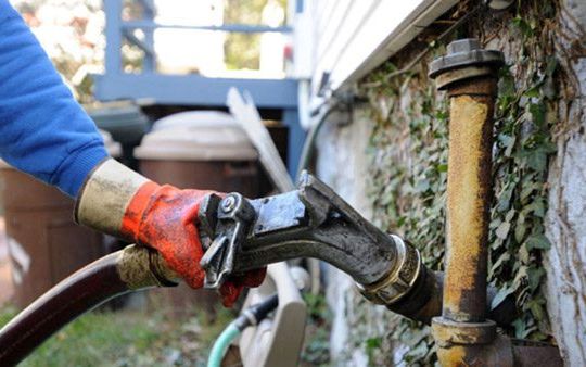 Fuel line connected at an older oil tank fill pipe before priming the burner