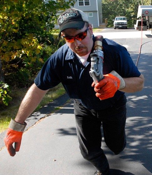 Heating oil driver hurrying a delivery nozzle up a driveway on an emergency call